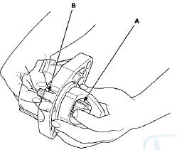 15. While holding the drive gear, turn the gear shaft
